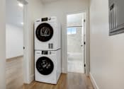 Thumbnail 5 of 11 - A white front loading washing machine in a small room.