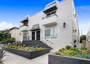 Thumbnail 10 of 11 - A modern house with a white exterior and a black roof.