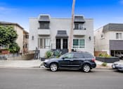 Thumbnail 11 of 11 - A black SUV is parked in front of a white two-story house.