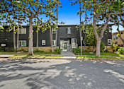 Thumbnail 8 of 11 - A black building with a tree in front of it.
