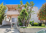 Thumbnail 10 of 12 - A white two-story house with a balcony on the second floor.