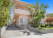 Thumbnail 12 of 12 - A house with a white exterior and a driveway.