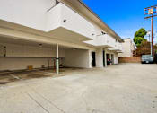 Thumbnail 3 of 3 - A large, empty parking garage with a clear blue sky above.
