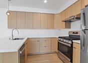 Thumbnail 3 of 12 - A modern kitchen with wooden cabinets and stainless steel appliances.