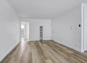 Thumbnail 8 of 35 - A room with wooden floors and white walls.