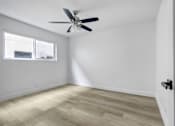 Thumbnail 13 of 35 - A room with a ceiling fan and a window.
