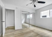 Thumbnail 16 of 35 - A room with a ceiling fan and sliding glass doors.