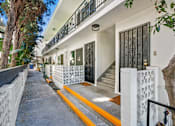Thumbnail 22 of 35 - A white building with a black gate and a yellow line on the sidewalk.