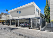 Thumbnail 23 of 35 - A white modern house with a black gate in front.