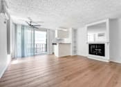 Thumbnail 1 of 12 - A spacious living room with a fireplace and a sliding glass door.