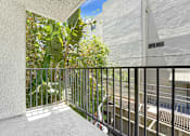 Thumbnail 2 of 12 - A balcony with a metal railing and plants on the side.