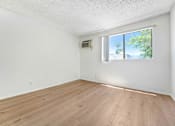 Thumbnail 6 of 12 - A room with a window and a wall-mounted air conditioning unit.