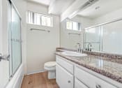Thumbnail 8 of 12 - A bathroom with a toilet, sink, and shower.
