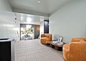 Thumbnail 10 of 12 - A living room with a brown leather chair and a coffee table.