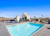 Thumbnail 11 of 12 - A swimming pool in a backyard with a white building in the background.