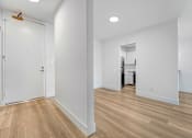 Thumbnail 15 of 56 - A white room with a wooden floor and a white door.