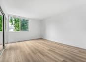 Thumbnail 16 of 56 - A room with a window and wooden flooring.
