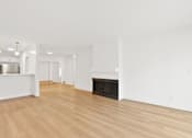 Thumbnail 32 of 56 - A large, empty room with a fireplace and wooden floors.