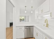 Thumbnail 33 of 56 - A kitchen with white cabinets and a stainless steel dishwasher.