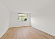 Thumbnail 36 of 56 - A room with a window and wooden flooring.