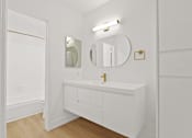 Thumbnail 38 of 56 - A white bathroom with a sink and mirror.