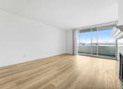 Thumbnail 1 of 56 - A room with wooden flooring and a large window with a view of the outside.