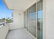 Thumbnail 2 of 56 - A balcony with a glass door and a railing.