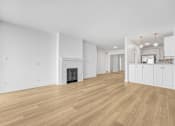 Thumbnail 3 of 56 - A large, empty room with wooden floors and a fireplace.