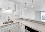 Thumbnail 5 of 56 - A kitchen with white cabinets and a marble countertop.