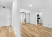 Thumbnail 6 of 56 - A white room with a wooden floor and a white door.