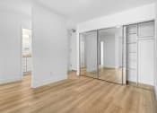 Thumbnail 9 of 56 - A room with a wooden floor and white walls.