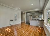 Thumbnail 2 of 16 - A spacious kitchen with wooden floors and a large island.