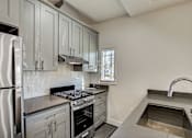 Thumbnail 3 of 16 - A kitchen with a stainless steel refrigerator, oven, and sink.