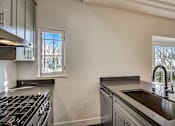 Thumbnail 4 of 16 - A modern kitchen with a stainless steel stove and dishwasher.