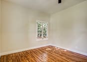 Thumbnail 8 of 16 - A room with a window and wooden flooring.