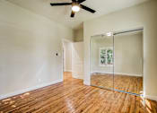 Thumbnail 9 of 16 - A room with a ceiling fan and a glass door leading to a balcony.