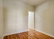 Thumbnail 12 of 16 - A room with a wooden floor and a door.
