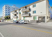 Thumbnail 7 of 13 - A street view of a residential area with cars parked on the side of the road.