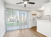Thumbnail 1 of 19 - A white kitchen with a sliding glass door leading to a backyard.