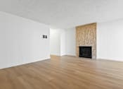 Thumbnail 4 of 19 - A room with a fireplace and wood flooring.