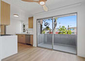 Thumbnail 10 of 19 - A kitchen with a white counter top and wooden cabinets.