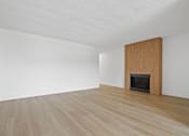 Thumbnail 12 of 19 - A room with a fireplace and wooden flooring.