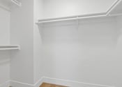 Thumbnail 14 of 19 - A white closet with two shelves and a wooden floor.