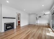 Thumbnail 17 of 29 - A spacious room with a fireplace and wooden flooring.