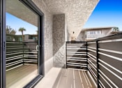 Thumbnail 19 of 29 - A balcony with a glass door and a concrete pillar.