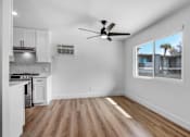 Thumbnail 20 of 29 - A room with a ceiling fan and a window overlooking a building.