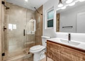 Thumbnail 23 of 29 - A modern bathroom with a walk-in shower and a toilet.