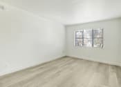 Thumbnail 8 of 14 - A room with a window covered by blinds.