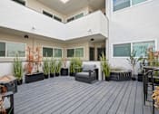 Thumbnail 12 of 14 - A balcony with a grey bench and black planters.