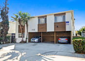 Thumbnail 2 of 3 - A two-story building with the number 118 on the front has a car parked in the garage.